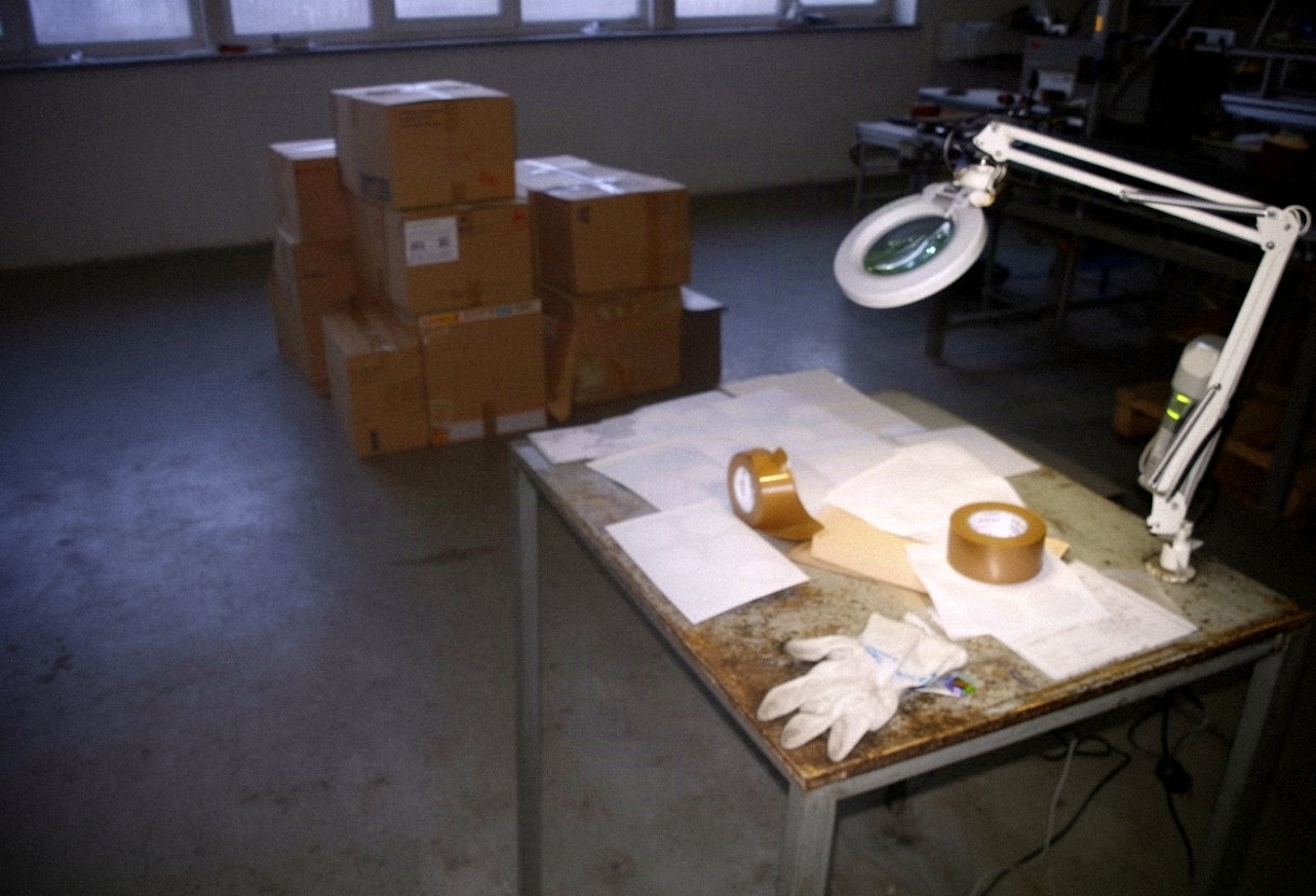Stół do pakowania i kontroli jakości z lampą z lupą w niewielkim zakładzie produkcyjnym